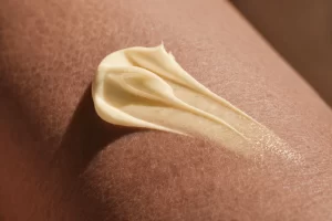 Texture beige ricarica crema solare SPF 50 viso stesa sulla pelle per protezione molto alta