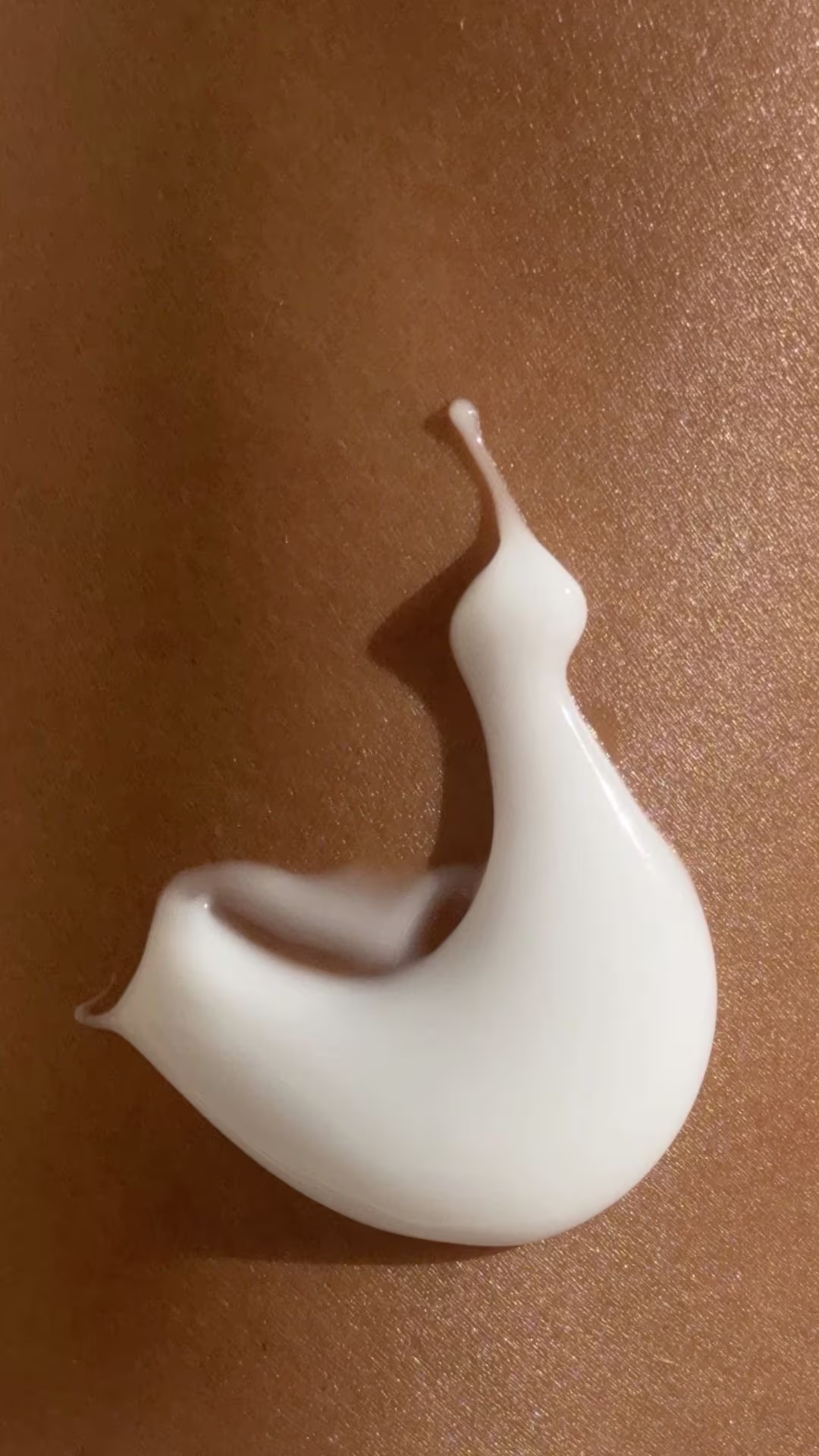 Texture bianca ricarica crema solare SPF 50 viso su pelle ambrata